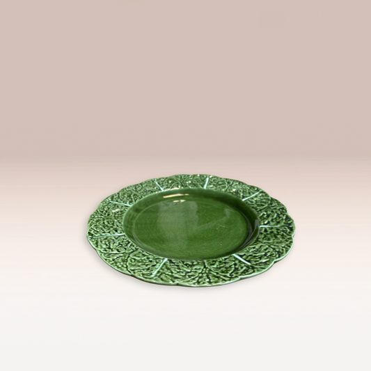 Assiette de taille moyenne avec des motifs feuille de chou sur les rebords.
