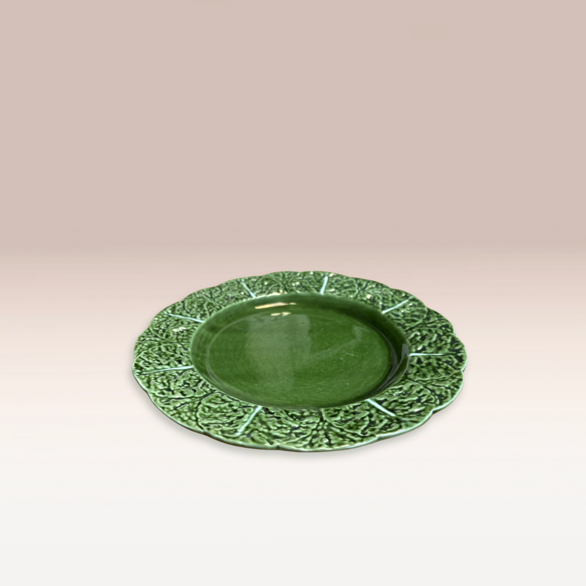 Assiette de taille moyenne de couleur vert foncé avec des motifs feuilles de chou sur les bords.