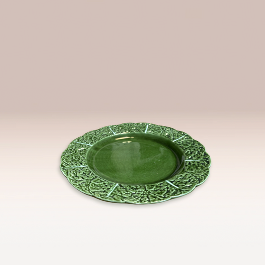 Assiette de taille moyenne de couleur vert foncé avec des motifs feuilles de chou sur les bords.