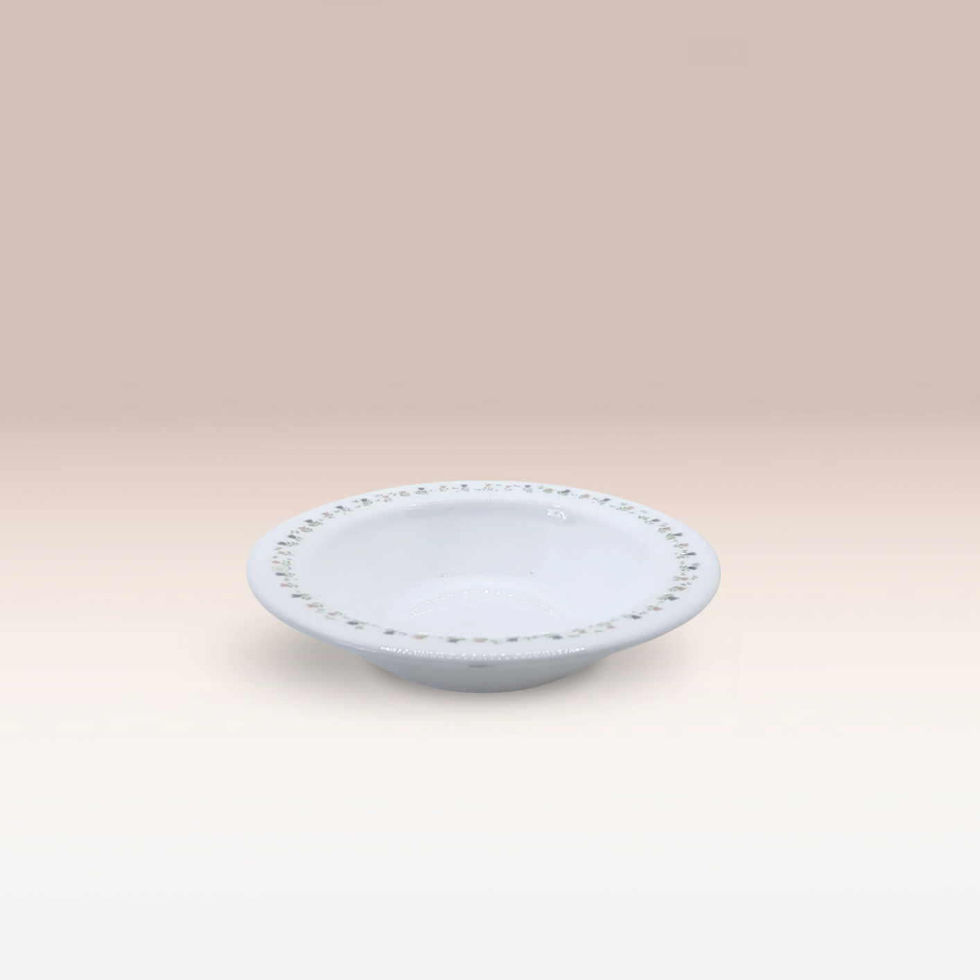 Petite coupelle blanche avec des motifs floraux sur les bords.