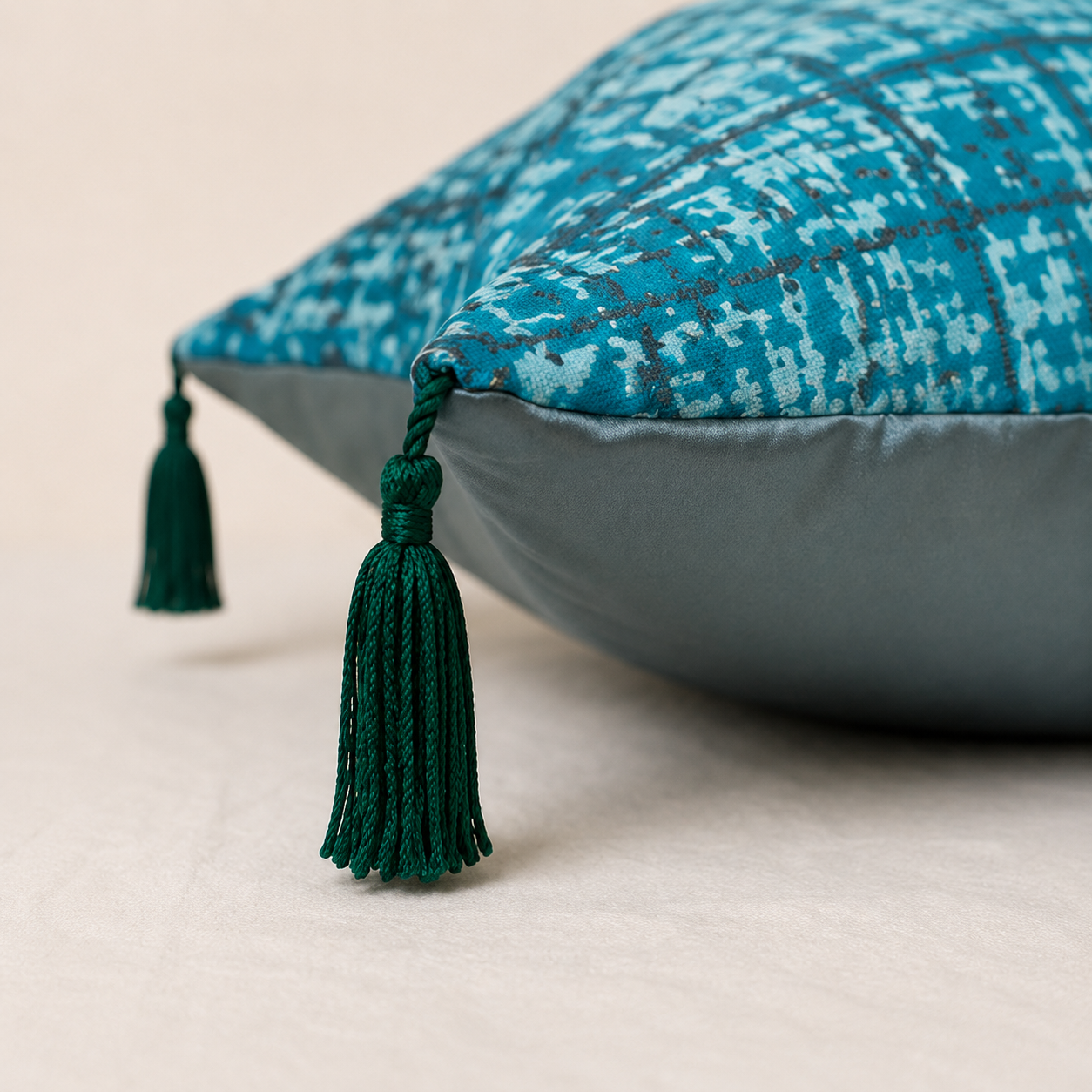 Détail du coussin décoratif turquoise et bleu-gris avec pampille – vue de profil