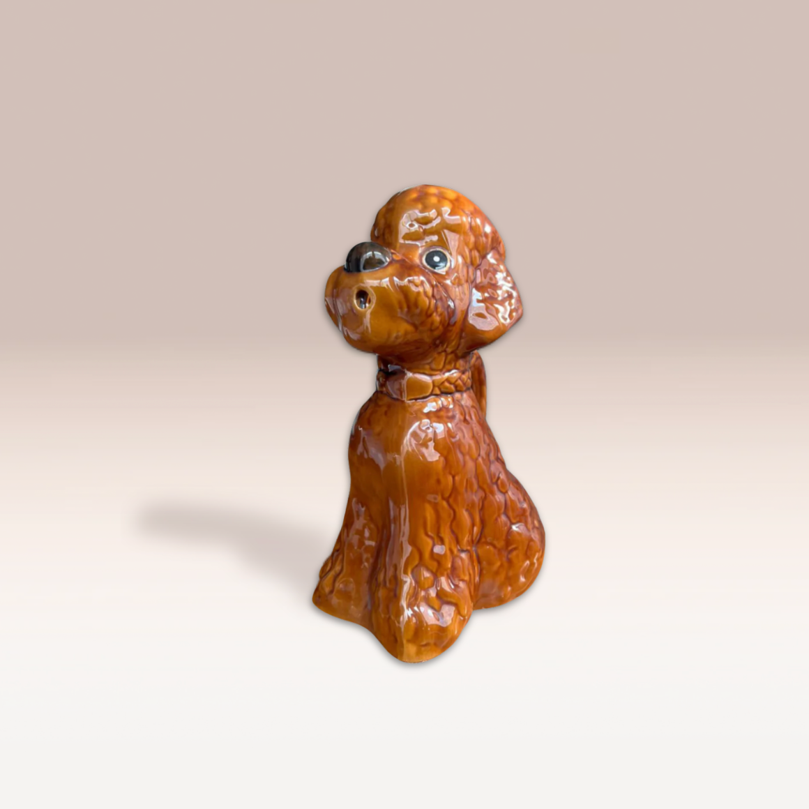 Pichet marron orangé en forme de chien. La faïence présente des détails en reliefs pour plus de réalisme.