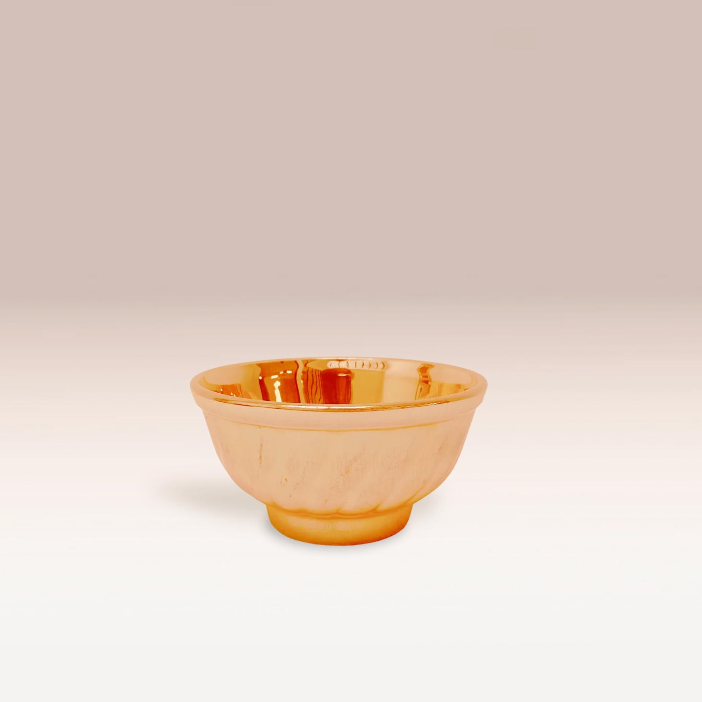 Bol de couleur orange abricot qui reflète la lumière grâce à ses reflets irisés.